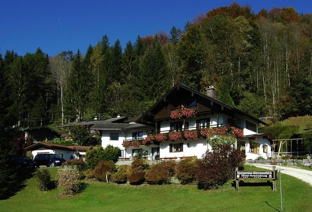 duży dom z kwiatami na przodzie w obiekcie Alpenpension Watzmannblick w mieście Bischofswiesen
