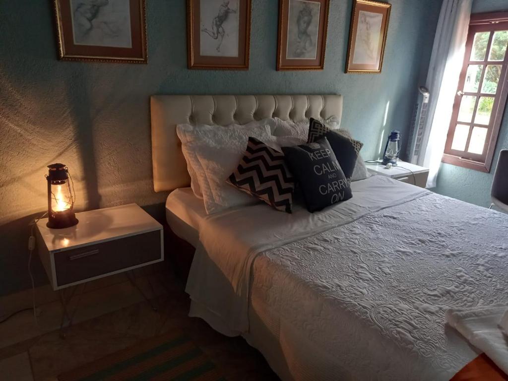 um quarto com uma cama com almofadas em Pousada Águas da Serra em Petrópolis
