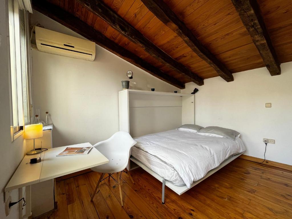 a bedroom with a white bed and a desk at Latina in Madrid