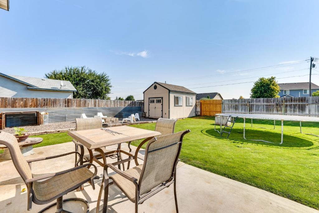 a patio with a table and chairs in a yard at Charming Nampa Home with Backyard and Grill! in Nampa