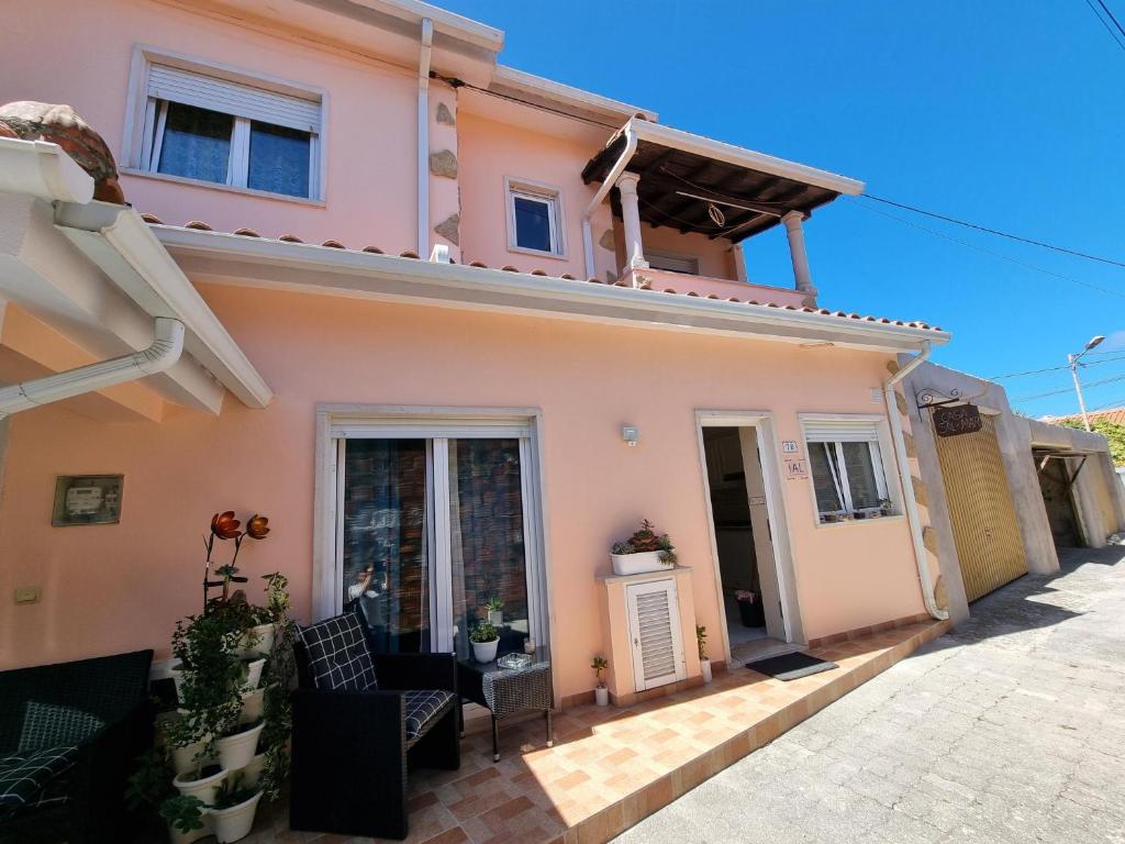 a pink house with a patio in front of it at Casa Sol e Mar 