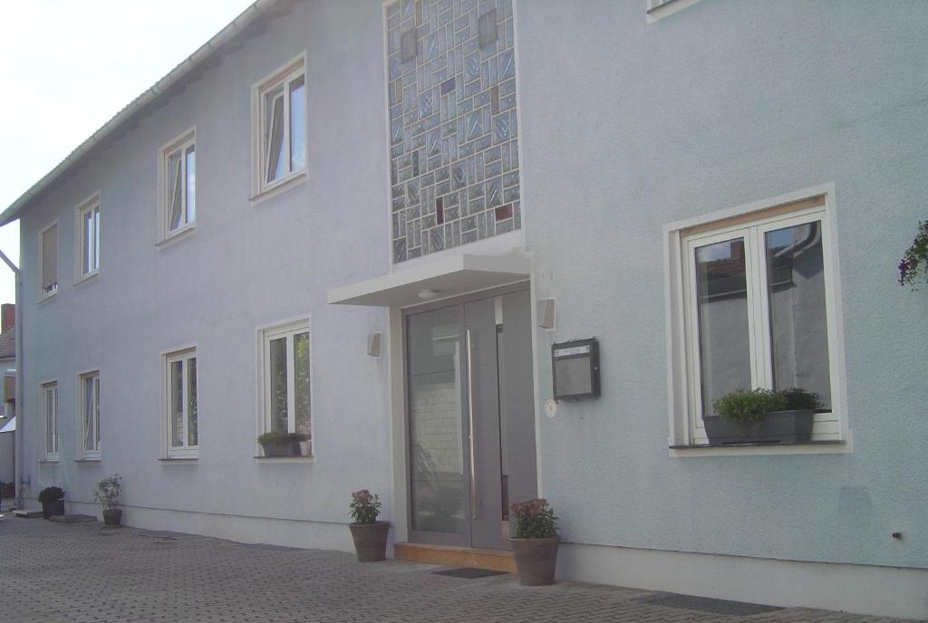 ein weißes Gebäude mit Topfpflanzen nebeneinander in der Unterkunft Hotel Garni Pension Ruth in Mutterstadt