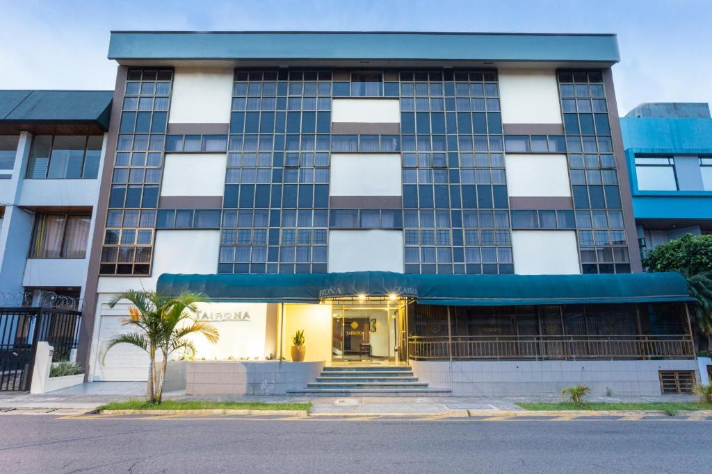 a building with a palm tree in front of it at Apartotel Tairona in San Pedro