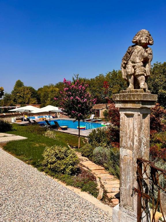 une statue d'un homme debout à côté d'une piscine dans l'établissement LaMirage - una vera oasi di pace, à Bozzolo