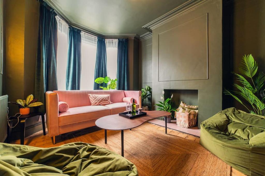 uma sala de estar com um sofá rosa e uma mesa em Kim's City Escape em Cardiff