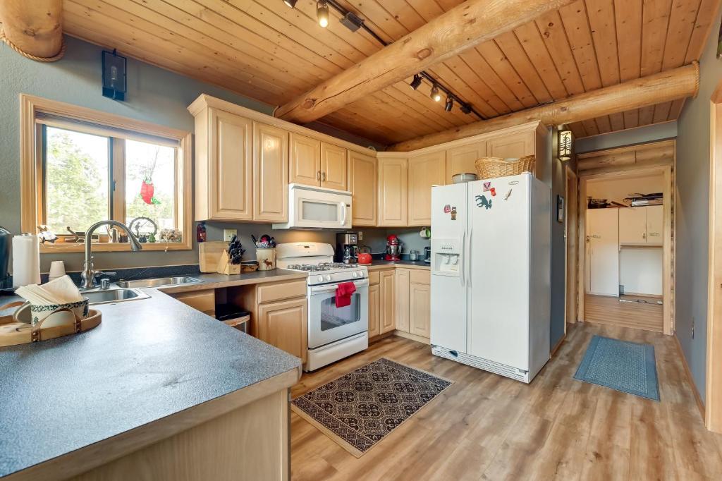 uma cozinha com um frigorífico branco e armários de madeira em Soldotna Fishing Lodges with Dock on Kenai River! em Sterling