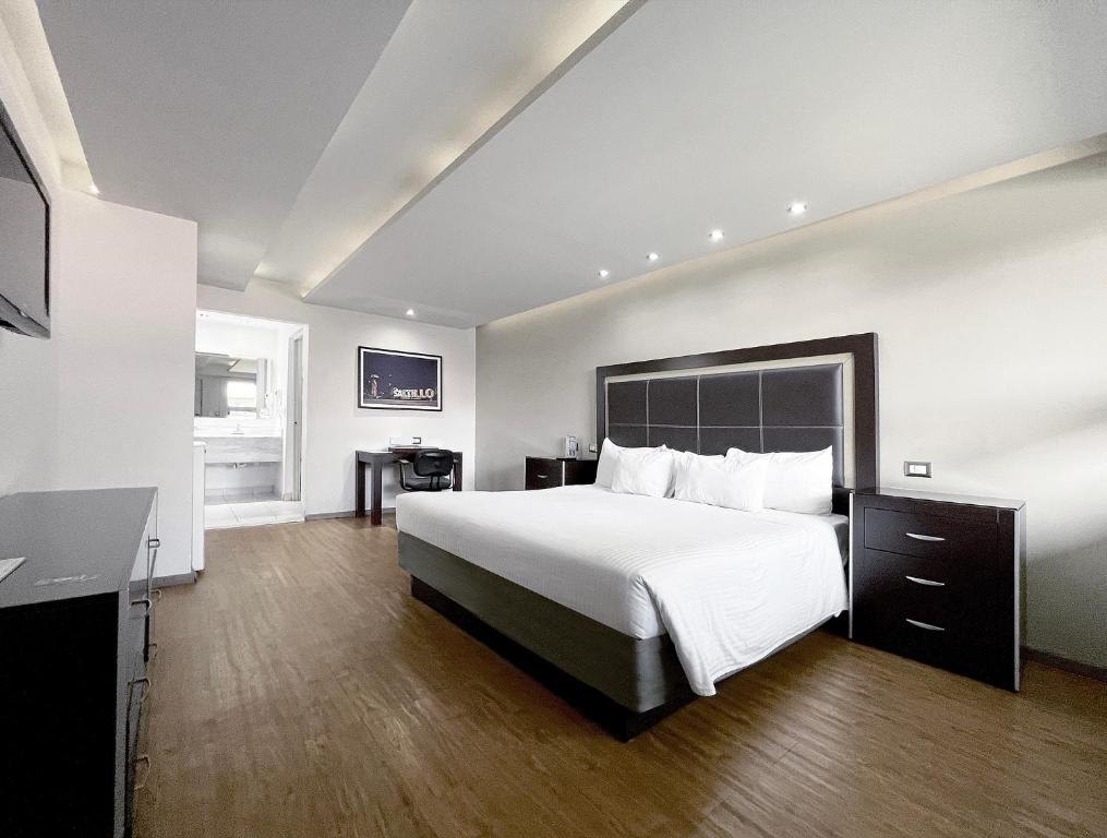 サルティーヨにあるQuinta Dorada Hotel & Suitesのベッドとデスクが備わるホテルルームです。