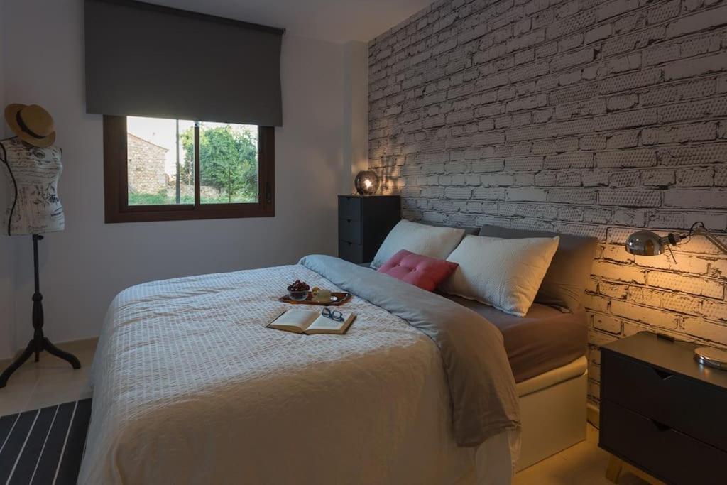 1 dormitorio con 1 cama grande y pared de ladrillo en Apartamento La Calma, en Lliber