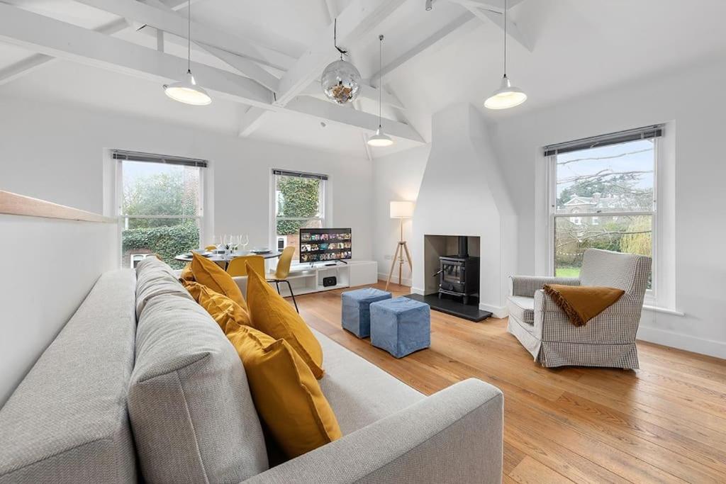 ein Wohnzimmer mit einem grauen Sofa und einem Kamin in der Unterkunft Flourish Apartments - The Annex - Dulwich Village in London