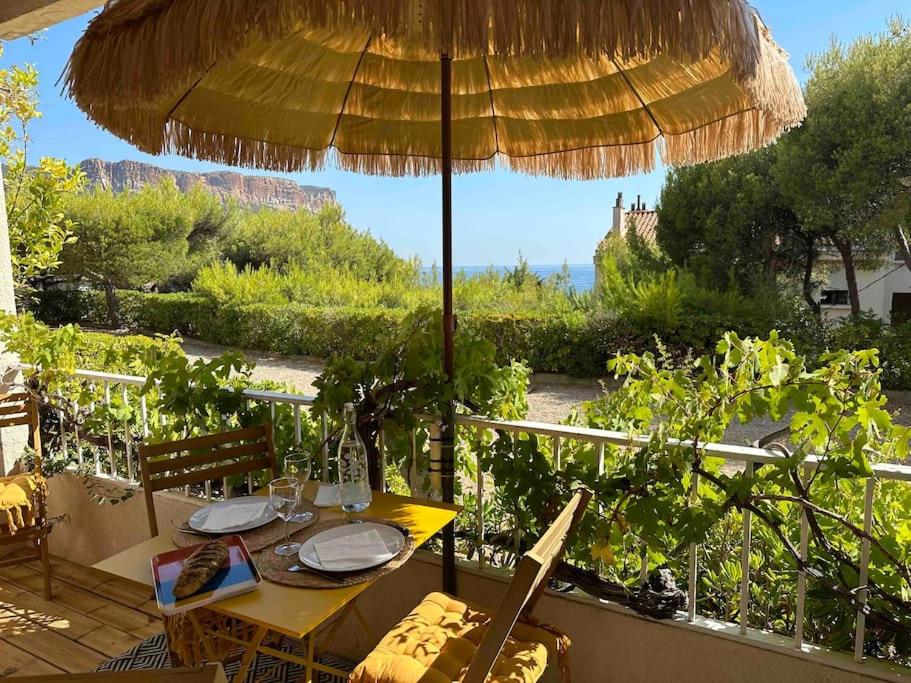 a table with an umbrella on a patio at Le repaire de la Vierge bohème vue mer in Cassis