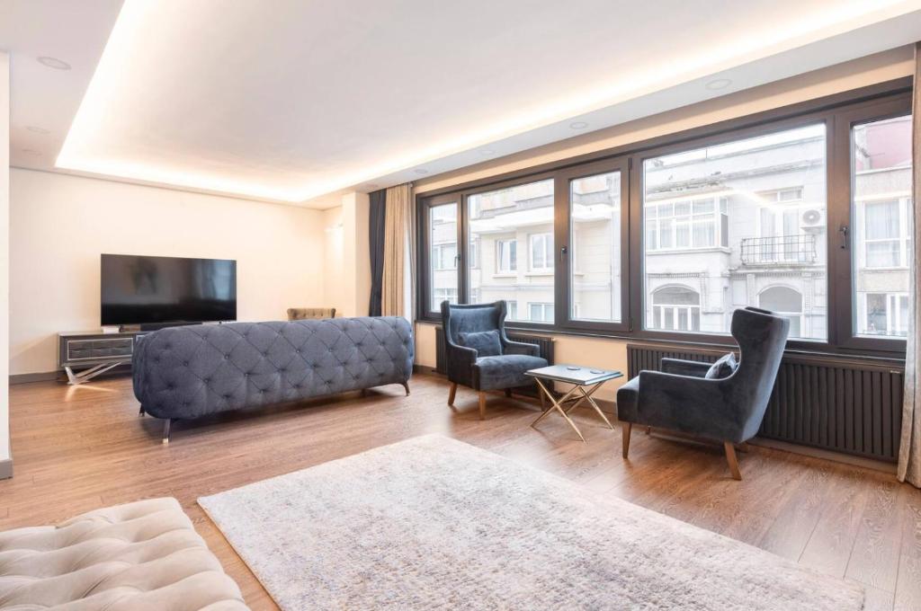 a living room with a couch and chairs and a television at Luxury apartment in the heart of Nisantasi in Istanbul