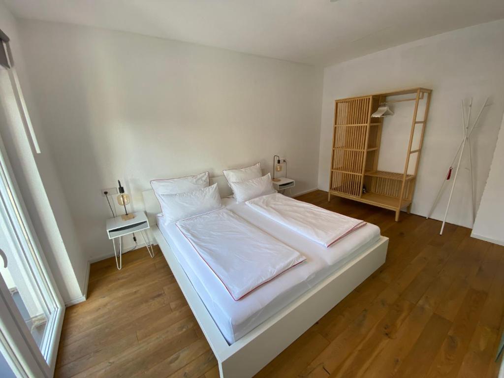 a white bed with white sheets and pillows in a room at Loft Appartement Seven in Friedrichshafen