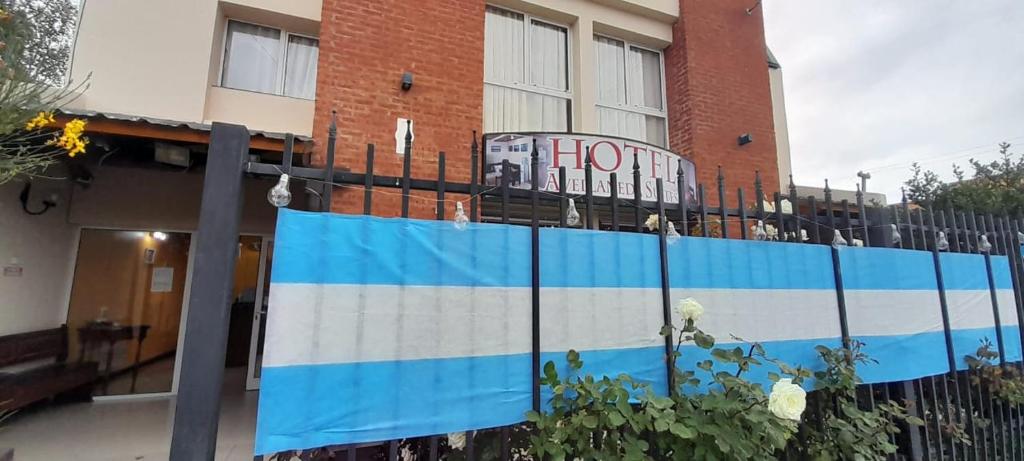 um edifício com uma cerca e um cartaz em avellaneda suites em Río Gallegos