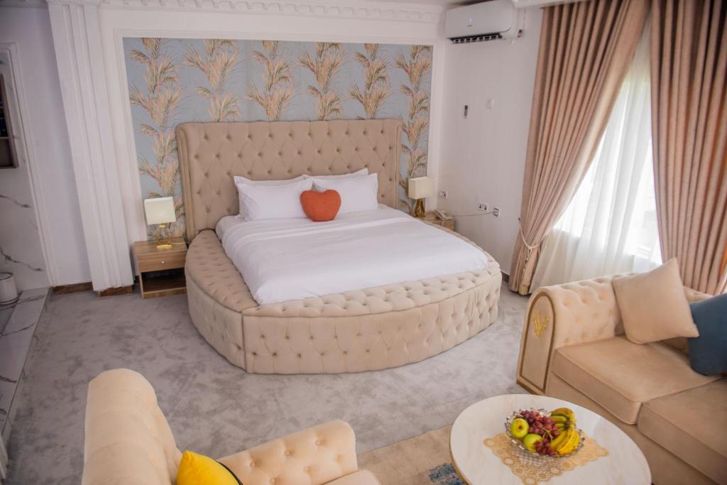 MONDEESTARS LUXURY HOME في إيبادان: سرير كبير في غرفة معيشة مع أريكة