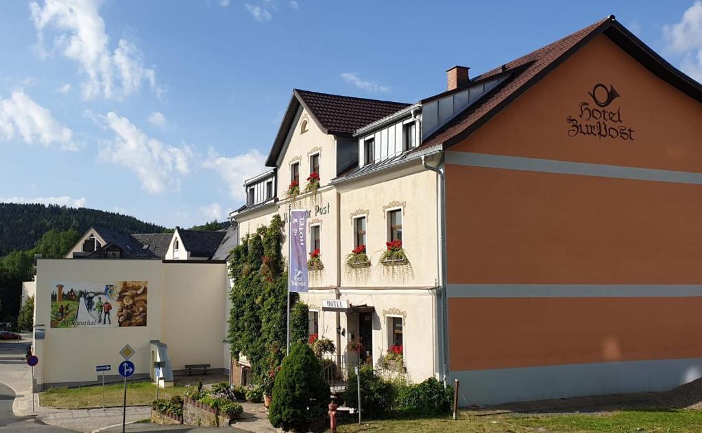 een gebouw met bloemen op de balkons bij Hotel zur Post in Klingenthal