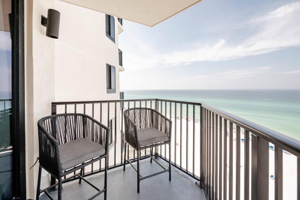 2 Stühle auf einem Balkon mit Meerblick in der Unterkunft Sunbird Sunsets in Panama City Beach