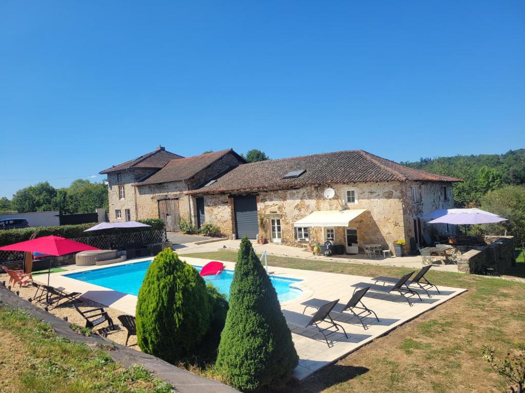 une villa avec une piscine en face d'une maison dans l'établissement Les hauts Brianço, à Solignac