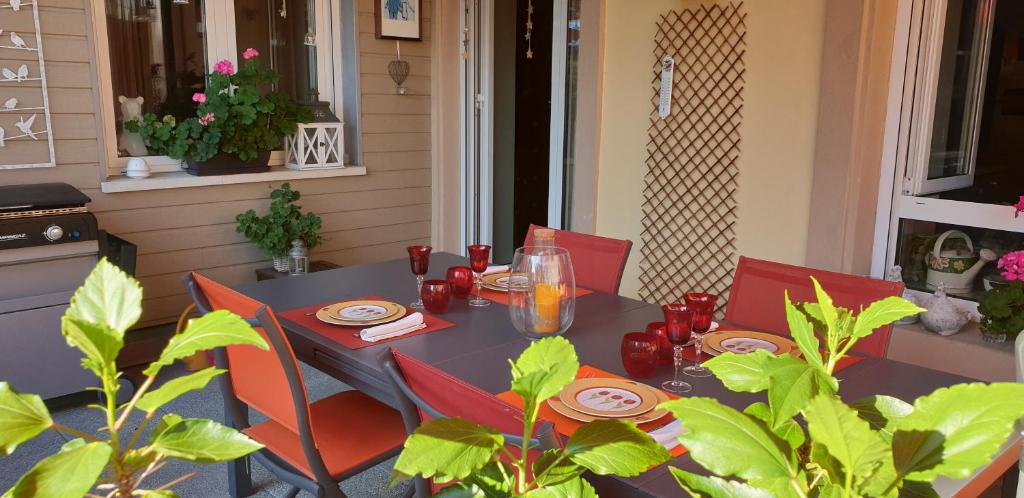 a table with red chairs sitting on a patio at Poésie en partage in Giromagny