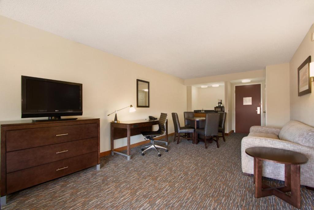 a hotel room with a couch and a television and a desk at Wingate by Wyndham - Chattanooga in Chattanooga
