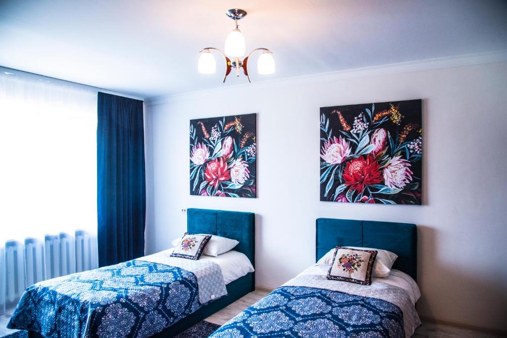 a bedroom with two beds and a chandelier at Studio apartment in Joniškis in Joniškis