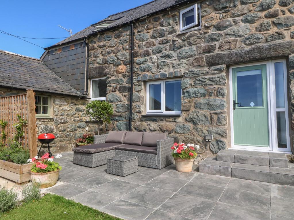 a patio in front of a stone house at Yr Ysgubor in Dyffryn