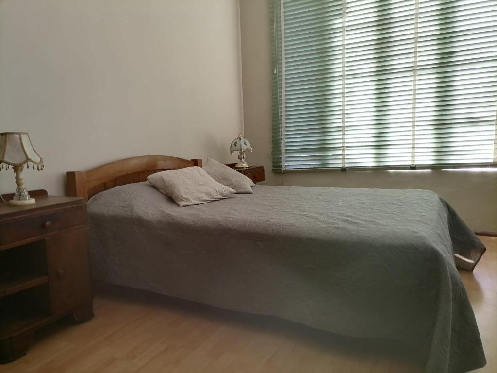 a bedroom with a bed and a table and a window at Apartamento Parra in Arequipa