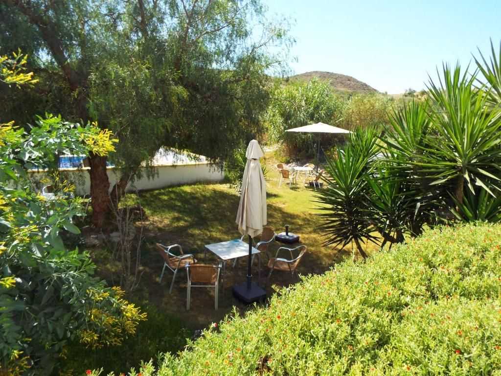 Arboleas的住宿－Casa Leon，庭院配有遮阳伞和桌椅。