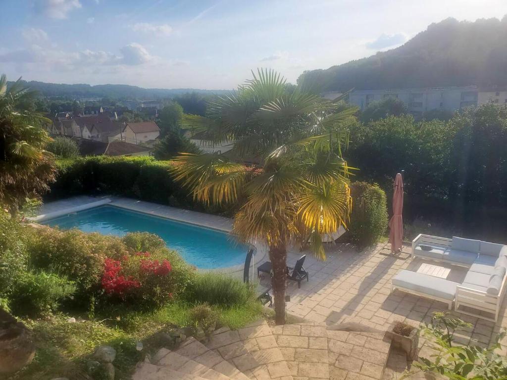 een zwembad in een tuin met een palmboom bij Villa de 5 chambres avec piscine privee jacuzzi et terrasse a Perigueux in Périgueux
