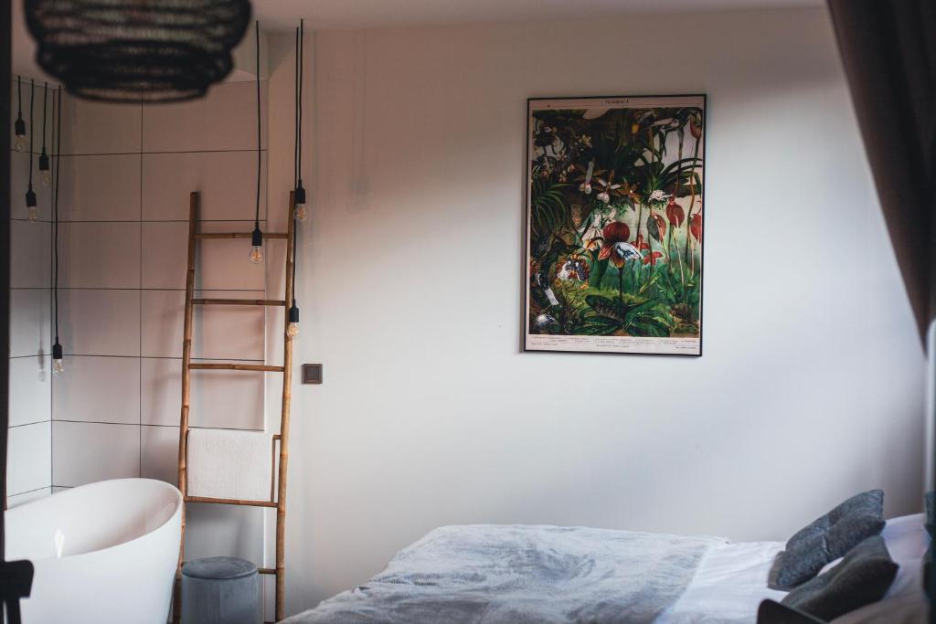 een slaapkamer met een schilderij aan de muur en een ladder bij GÓRNA VIBES in Jugowice