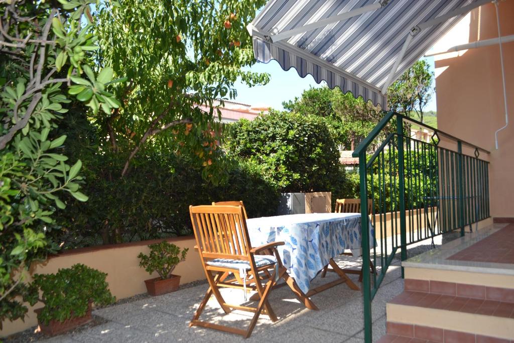 uma mesa e cadeiras sentadas sob um guarda-sol em La Limonaia em Marciana Marina