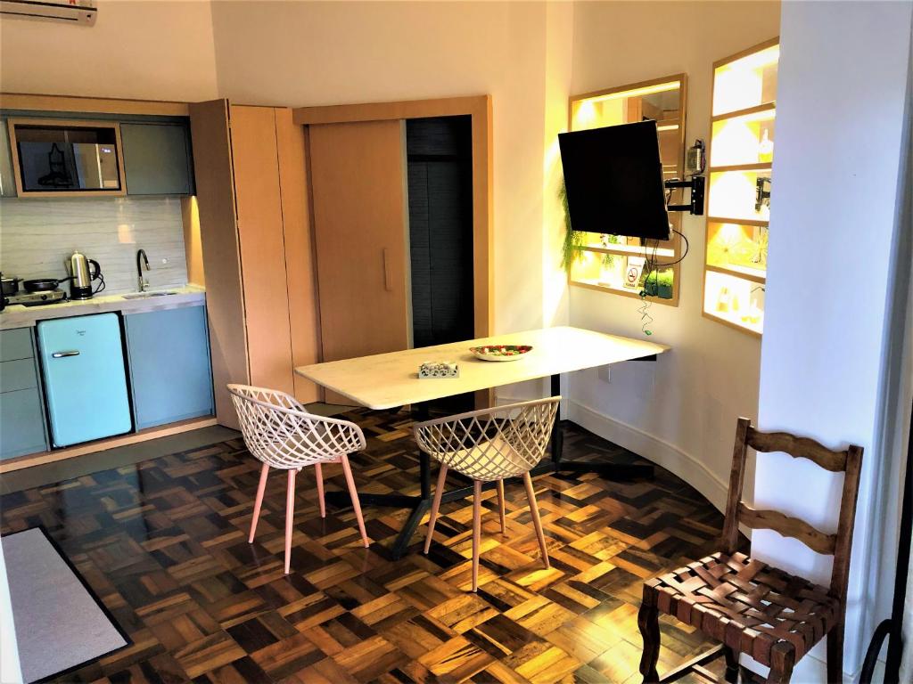 una pequeña cocina con mesa y 2 sillas en Apto MILAO na Vila Paraíso, prático e relaxante en Maringá