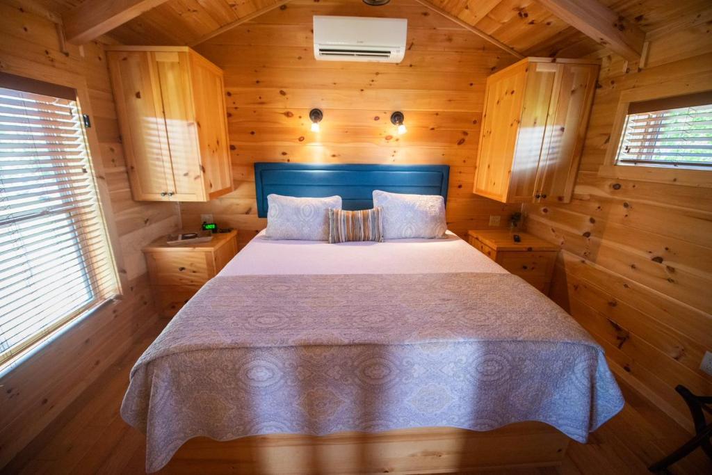 a bedroom with a bed in a wooden cabin at Juneberry Ridge in Norwood