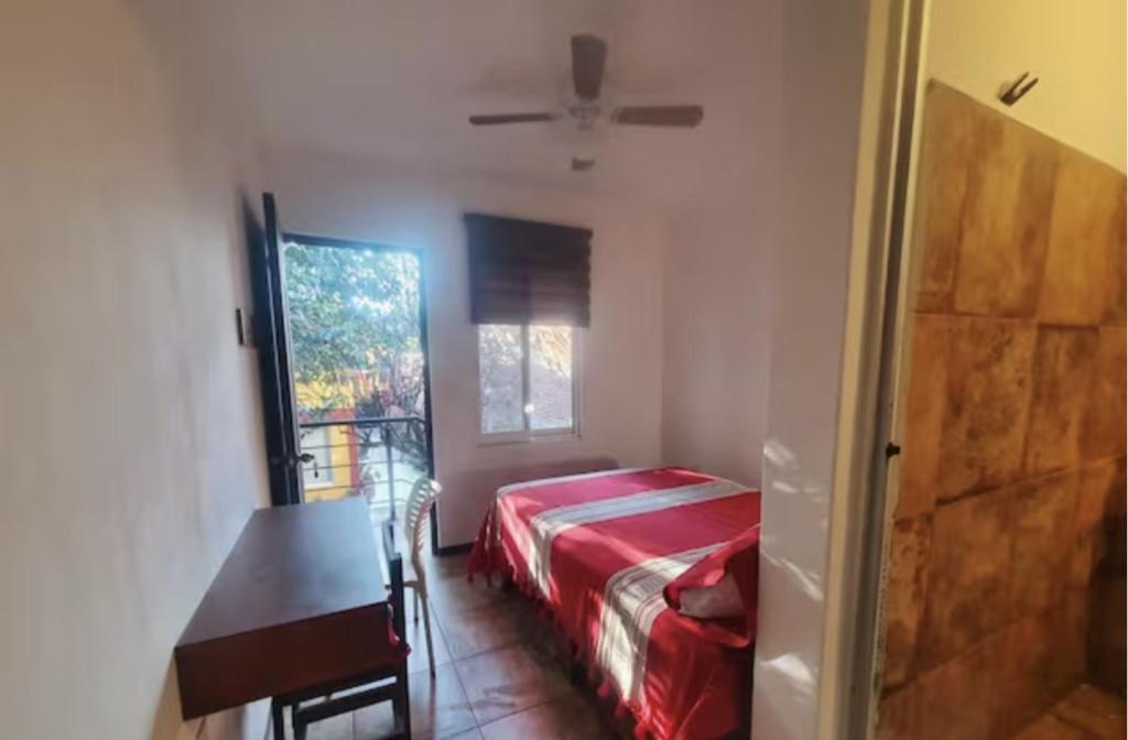 um quarto com uma cama, uma mesa e uma janela em Casa Juárez 2 em Oaxaca City