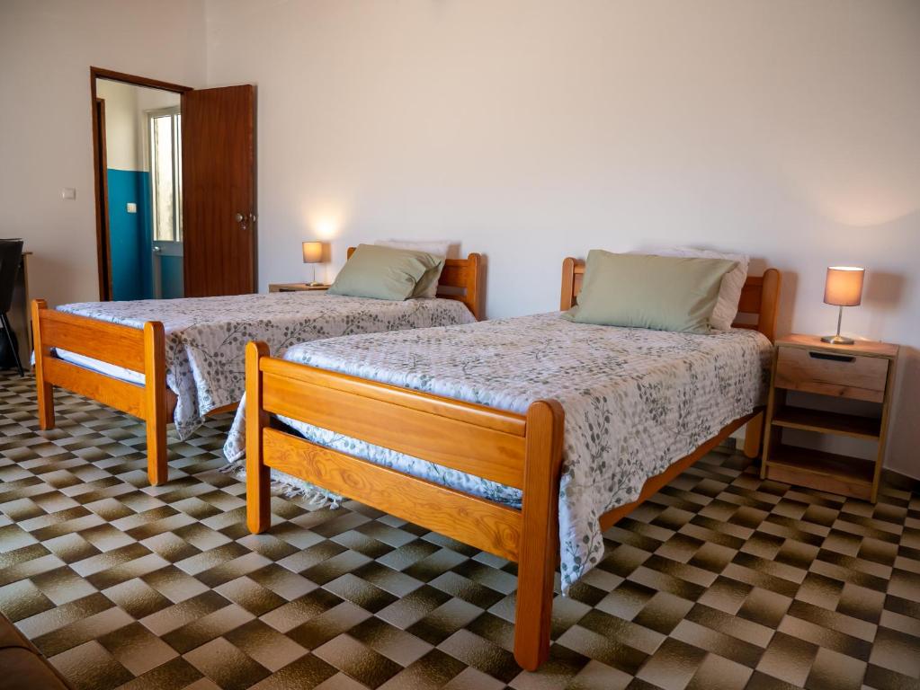 2 camas en una habitación con 2 lámparas en las mesas en Casa Olívia en Carrapateira