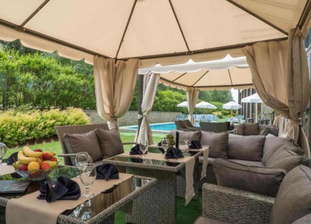 a patio with couches and tables and an umbrella at Apartament by Zenit in Terra Complex C30 in Razlog