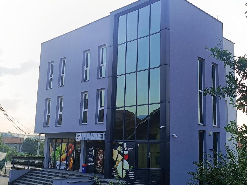 a large blue building with glass windows at Grand Apartman in Živinice