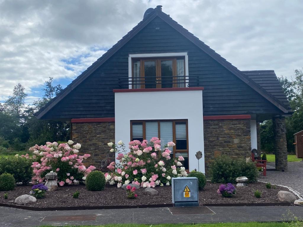 una piccola casa con fiori rosa di fronte di 2 Caragh Glen a Killorglin