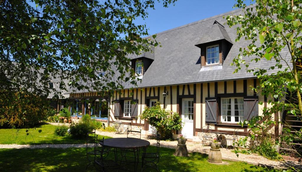 a house with a table in front of it at Le Bois des Pierres in Conteville