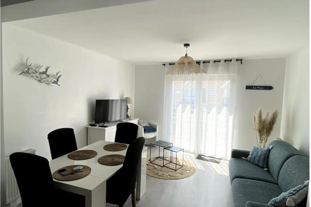 a living room with a table and a couch at Appartement Stella-Plage in Cucq
