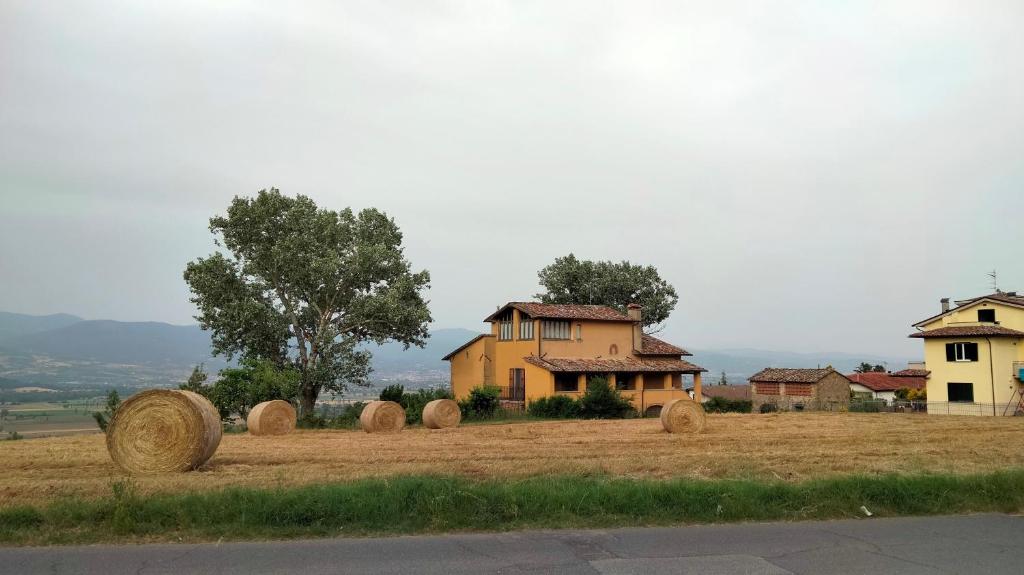 een veld met hooibalen voor een huis bij Vigna del Poggio in Anghiari