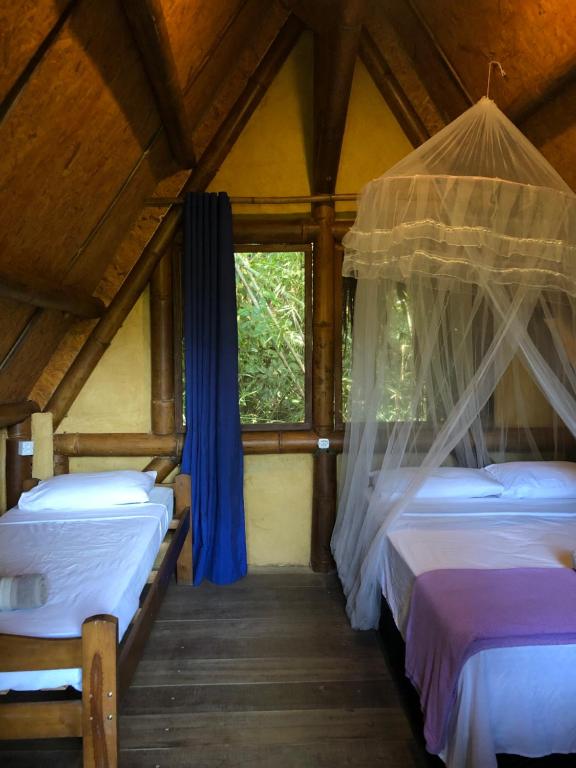 a room with two beds and a window at Sitio Simple Life in Ubatuba