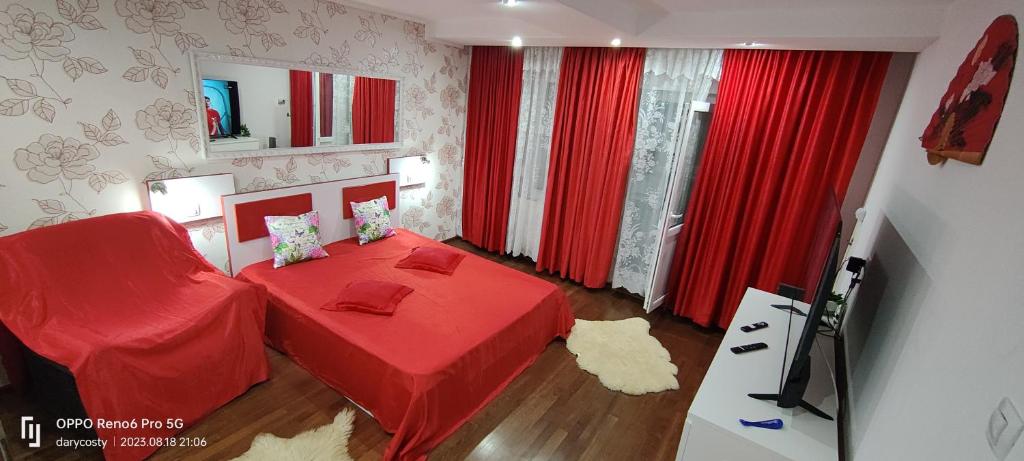 1 dormitorio con cama roja y cortinas rojas en Lake View Mall en Bacău