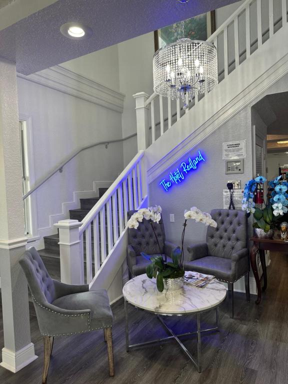 a lobby with two chairs and a table and a staircase at The Hotel Redland in Homestead