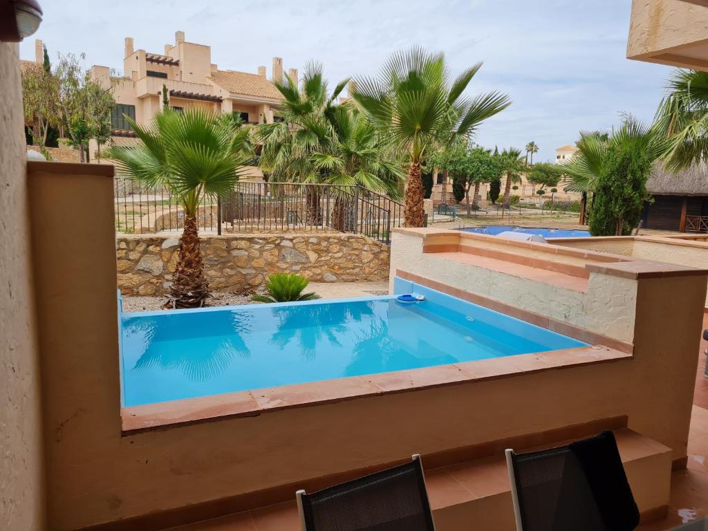 uma piscina num resort com palmeiras em Casa Lima em Múrcia