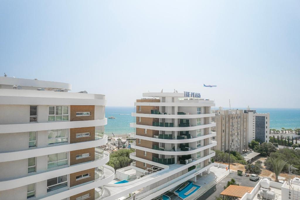 eine Luftansicht auf zwei hohe Gebäude und das Meer in der Unterkunft Seaview Pearl Suite Larnaca in Larnaka