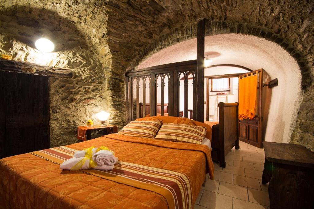 a bedroom with two beds in a stone room at Maison Mariot in Roure Turin