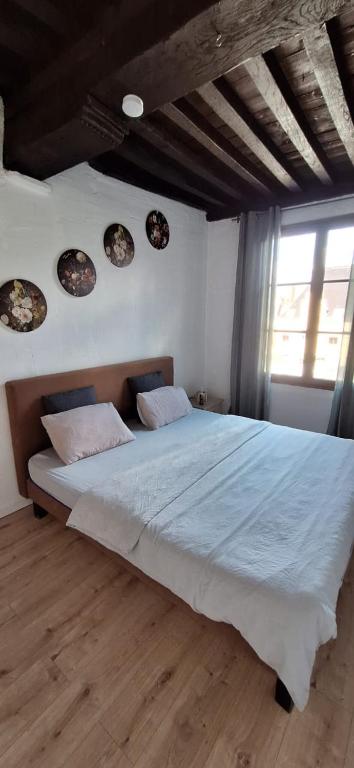 a bedroom with a large bed with blue sheets and a window at The 16th Century 2BR Apartment in The City Center in Antwerp