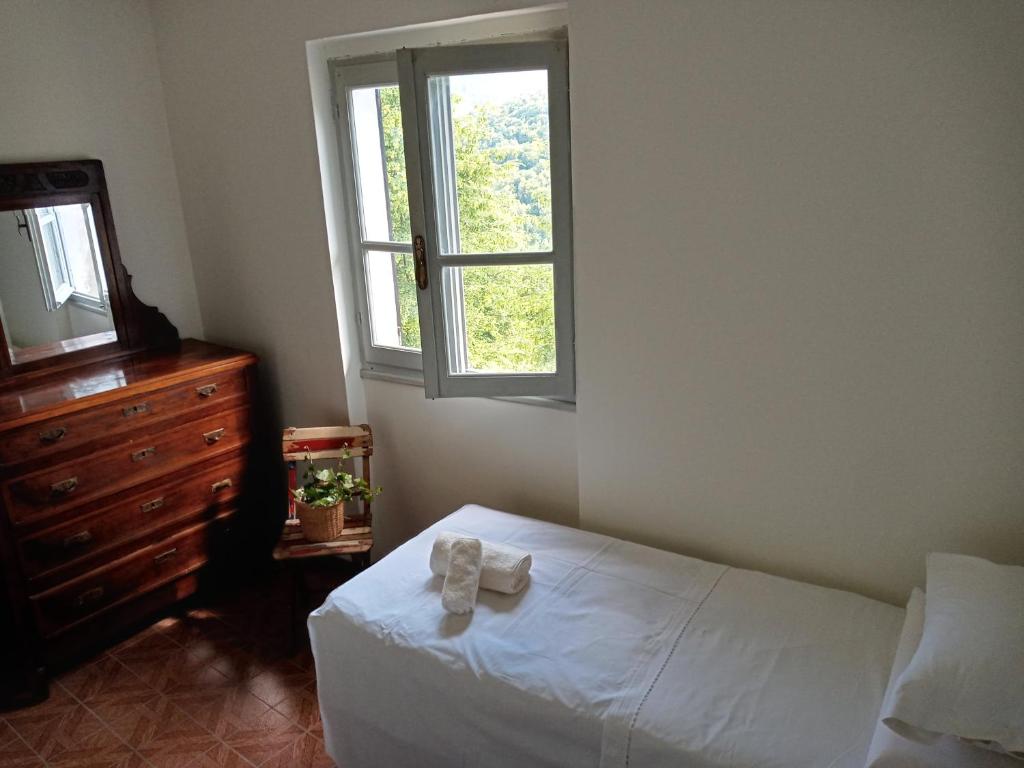 um quarto com uma cama, uma janela e uma cómoda em Ai Grilli - Ospitalità e natura em Casto