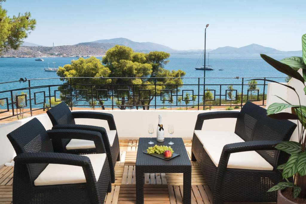 a patio with chairs and a table with a view of the ocean at Varkiza Sea Front Residence in Vari