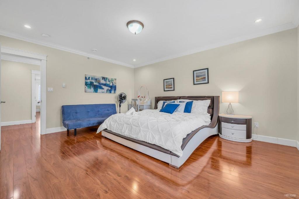 um quarto com uma cama grande e uma cadeira azul em Luxurious Getaway in Vancouver-Private room with attached bathroom em Vancouver